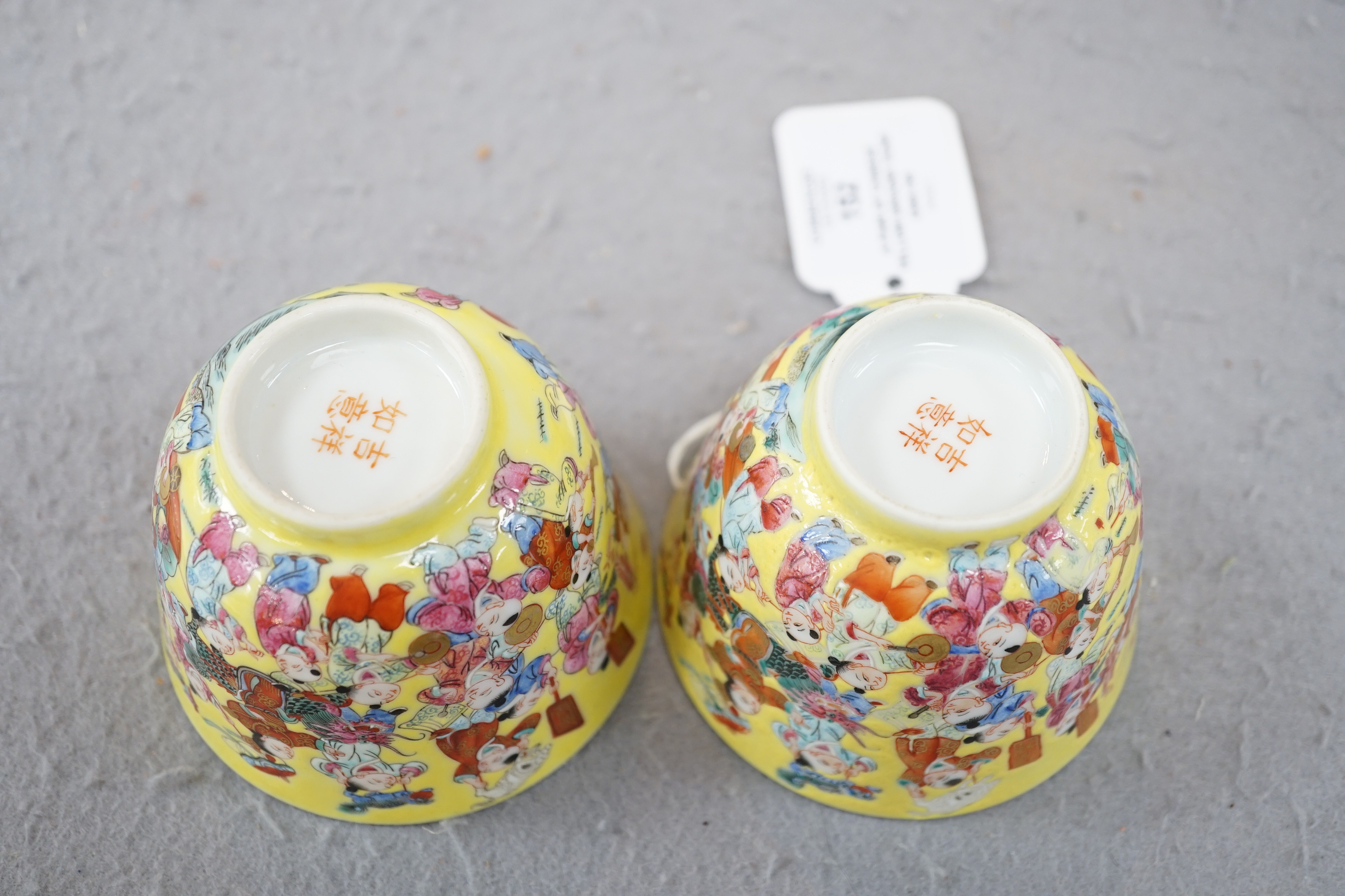 A pair of Chinese yellow ground 'Hundred Boys’ cups, 19th century, 6.5cm high 8.5cm diameter
